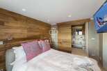 Experience luxury in this stunning bedroom featuring a unique wooden accent wall.