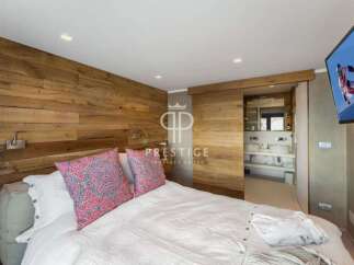 Experience luxury in this stunning bedroom featuring a unique wooden accent wall.