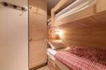 Discover a cozy bedroom featuring a charming bunk bed, perfect for accommodating guests or family.