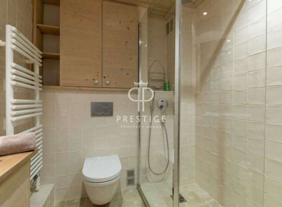 Discover a luxurious bathroom featuring a sleek glass shower enclosure.