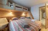 Discover the charm of this cozy bedroom featuring a unique bunk bed design, perfect for families or groups.