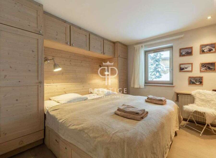 Cozy bedroom with wooden accents and a comfortable bed.