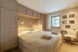 Cozy bedroom with wooden accents and a comfortable bed.