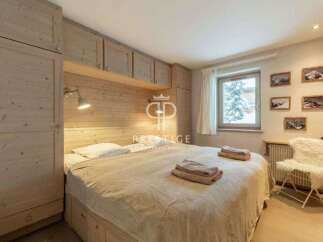 Cozy bedroom with wooden accents and a comfortable bed.