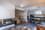 Discover luxury living in this stunning property, featuring a cozy fireplace and a modern kitchen.