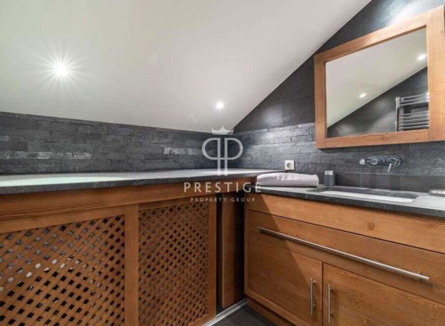 Discover luxury living in this stunning property! Featuring a modern bathroom design with sleek countertops and wooden cabinetry.