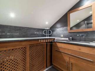 Discover luxury living in this stunning property! Featuring a modern bathroom design with sleek countertops and wooden cabinetry.