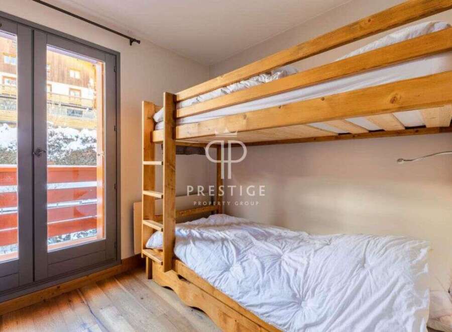 Discover a cozy bedroom featuring a charming wooden bunk bed, perfect for accommodating guests.