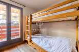 Discover a cozy bedroom featuring a charming wooden bunk bed, perfect for accommodating guests.