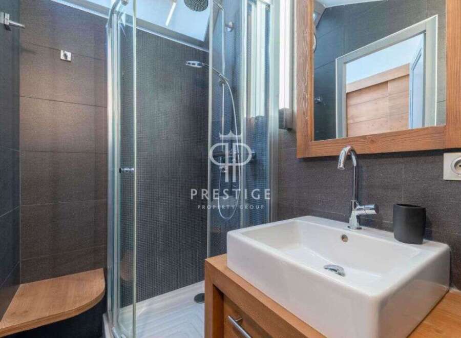 Discover a modern bathroom design featuring a sleek shower and a stylish sink.