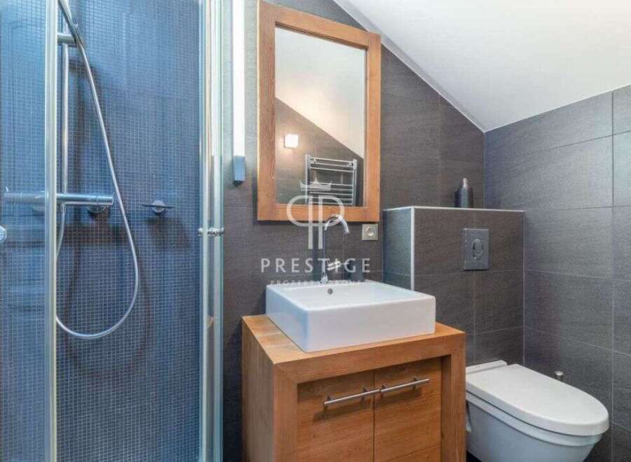 This modern bathroom features a sleek design with a walk-in shower and a stylish vanity.