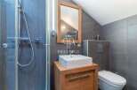 This modern bathroom features a sleek design with a walk-in shower and a stylish vanity.