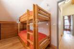 Discover a cozy bedroom featuring a charming wooden bunk bed, perfect for accommodating guests or family.