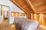 Discover the charm of this cozy bedroom featuring a stunning wooden ceiling and walls, creating a warm and inviting atmosphere.