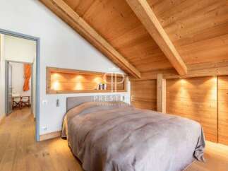 Discover the charm of this cozy bedroom featuring a stunning wooden ceiling and walls, creating a warm and inviting atmosphere.