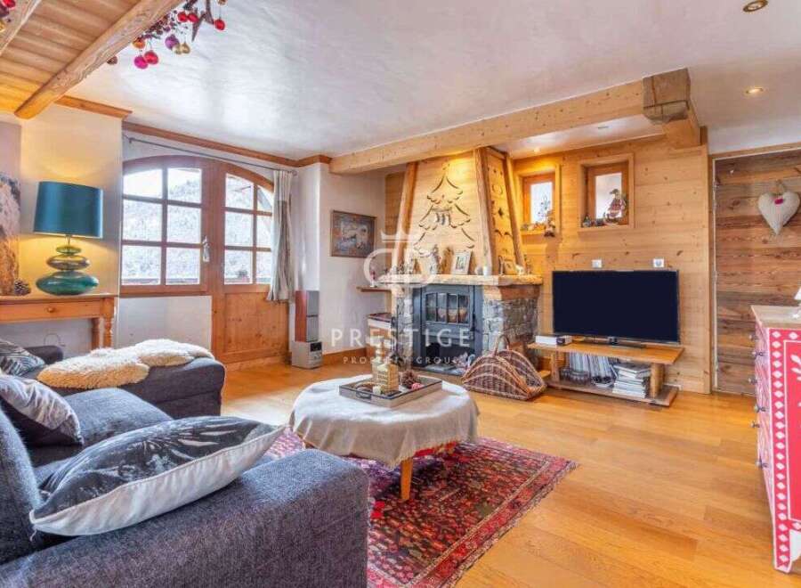 Experience the charm of this cozy living room, featuring a rustic fireplace and wooden accents.