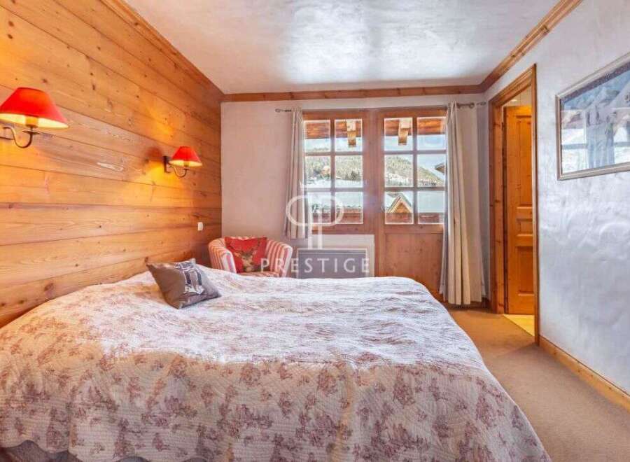 Cozy bedroom with wooden walls and a comfortable bed.