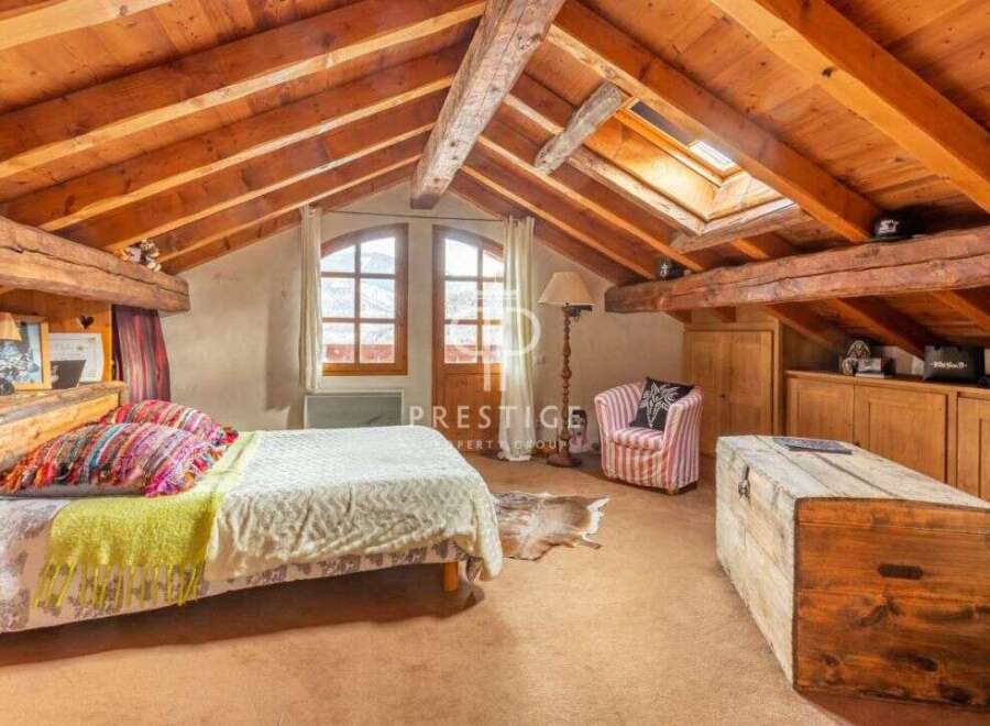 Discover the charm of this cozy bedroom with its rustic wooden beams and inviting atmosphere.