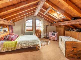 Discover the charm of this cozy bedroom with its rustic wooden beams and inviting atmosphere.