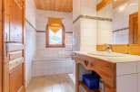 Discover the charm of this bathroom, featuring a wooden vanity and a cozy ambiance.