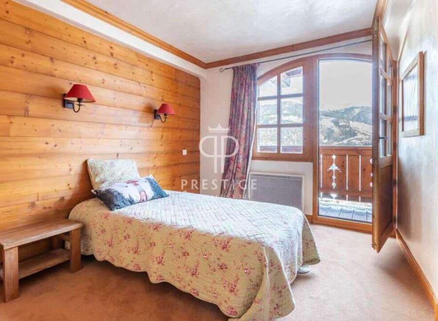 Cozy bedroom with wooden walls and a charming bedspread.