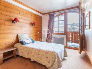 Cozy bedroom with wooden walls and a charming bedspread.