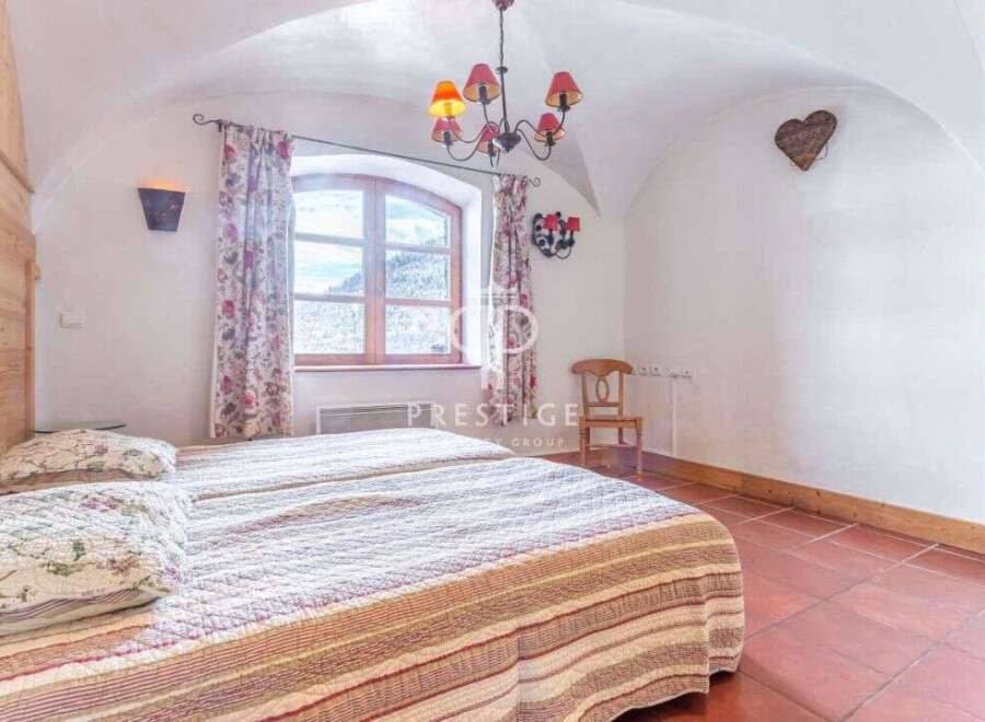 Discover the charm of this cozy bedroom, featuring a unique arched ceiling and rustic wooden accents.