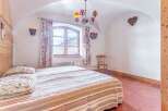 Discover the charm of this cozy bedroom, featuring a unique arched ceiling and rustic wooden accents.
