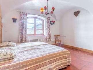 Discover the charm of this cozy bedroom, featuring a unique arched ceiling and rustic wooden accents.