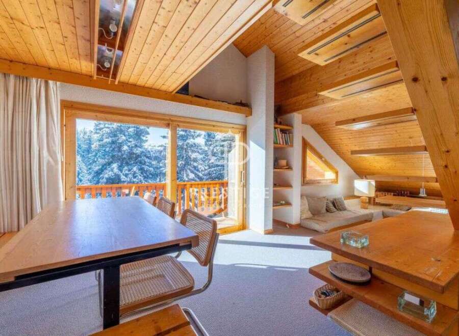 Experience the charm of this cozy mountain retreat, featuring stunning views of snow-covered trees through expansive windows.
