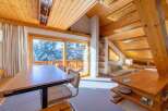 Experience the charm of this cozy mountain retreat, featuring stunning views of snow-covered trees through expansive windows.