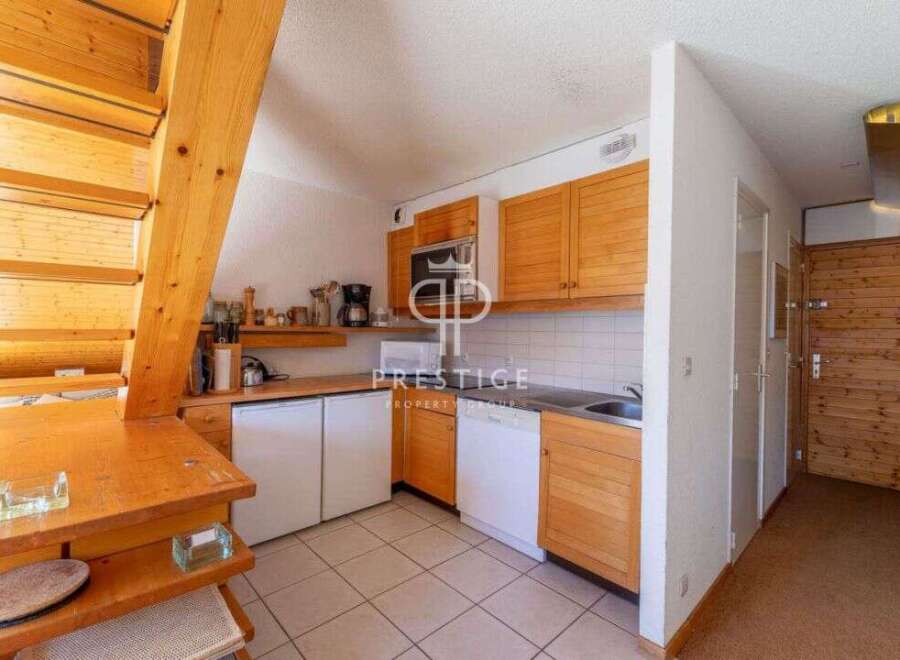 Discover a charming kitchen with wooden cabinets and a cozy dining area.