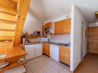 Discover a charming kitchen with wooden cabinets and a cozy dining area.