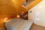 Discover the charm of this cozy bedroom with its unique wooden sloped ceiling.