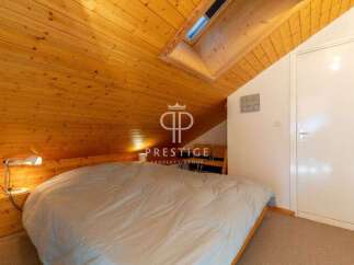 Discover the charm of this cozy bedroom with its unique wooden sloped ceiling.