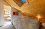 Discover the charm of this cozy bedroom, featuring a unique sloped wooden ceiling and a skylight that floods the space with natural light.
