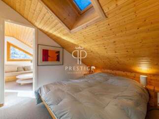 Discover the charm of this cozy bedroom, featuring a unique sloped wooden ceiling and a skylight that floods the space with natural light.