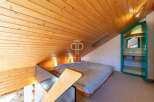 Discover a cozy loft space with a unique wooden ceiling design.
