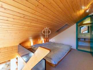 Discover a cozy loft space with a unique wooden ceiling design.