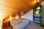 Discover a cozy bedroom with a unique sloped ceiling and wooden accents.