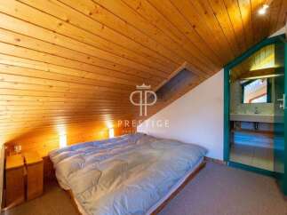Discover a cozy bedroom with a unique sloped ceiling and wooden accents.