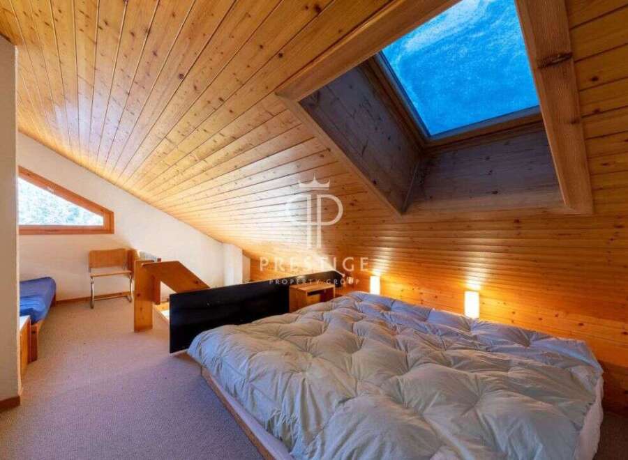Discover a cozy retreat with this charming bedroom featuring a unique wooden ceiling and a skylight that floods the space with natural light.