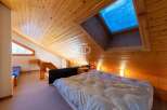 Discover a cozy retreat with this charming bedroom featuring a unique wooden ceiling and a skylight that floods the space with natural light.