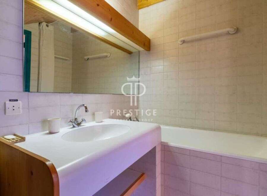 Discover a charming bathroom featuring a sleek sink and a relaxing bathtub.