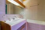 Discover a charming bathroom featuring a sleek sink and a relaxing bathtub.
