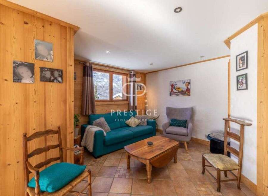 Cozy living room with wooden accents and a comfortable teal sofa.