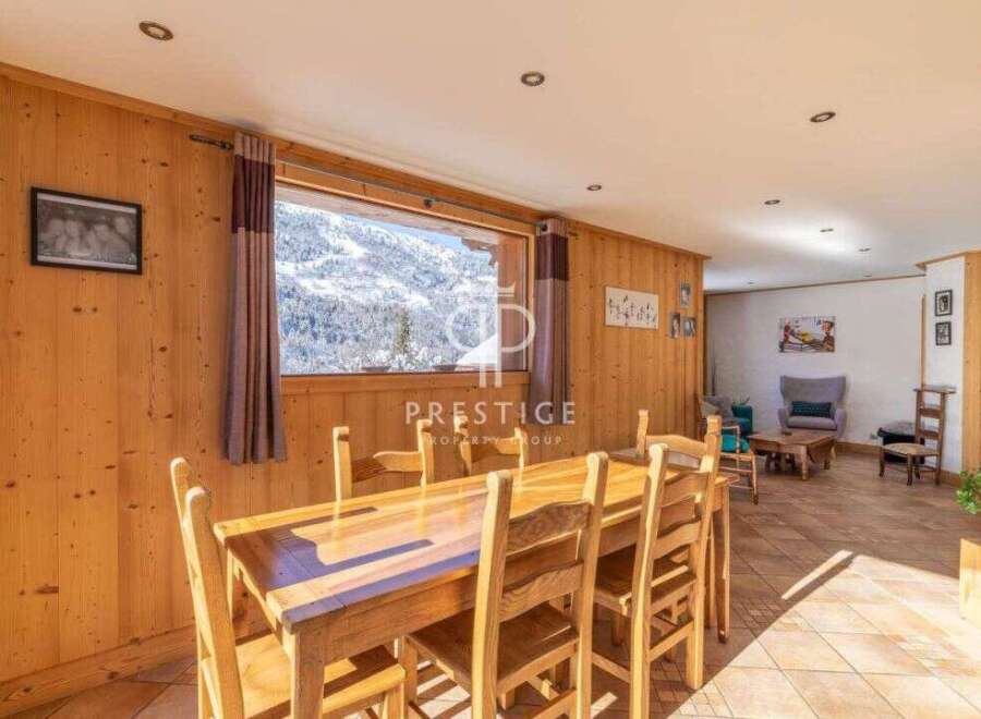 Experience the charm of this stunning property, featuring a cozy dining area with a beautiful wooden table and chairs.