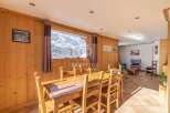 Experience the charm of this stunning property, featuring a cozy dining area with a beautiful wooden table and chairs.