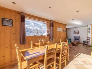 Experience the charm of this stunning property, featuring a cozy dining area with a beautiful wooden table and chairs.