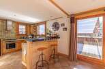Discover the charm of this cozy kitchen, featuring rustic wooden cabinetry and a stylish breakfast bar.